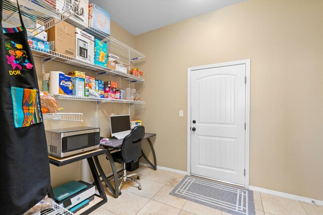 office area with a textured ceiling and light tile patterned floors