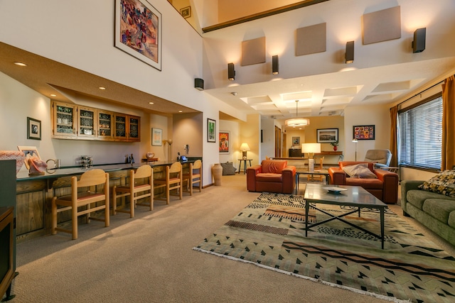 carpeted living room featuring coffered ceiling, beamed ceiling, and bar area