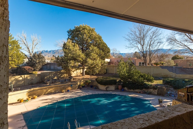 view of swimming pool featuring a mountain view and a patio area