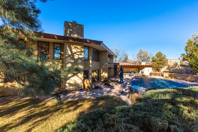 rear view of house featuring a patio and a lawn