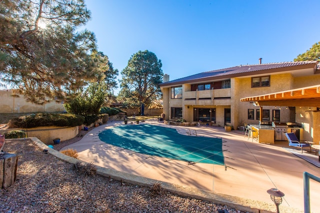 view of pool with a patio and exterior kitchen