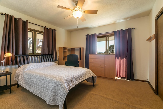 carpeted bedroom featuring ceiling fan and a textured ceiling