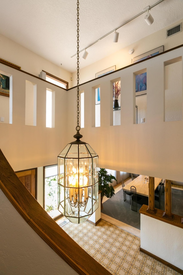 interior details with a textured ceiling and a notable chandelier