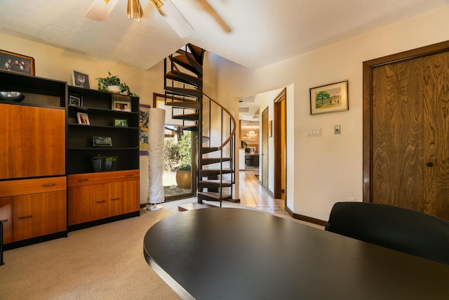 carpeted home office with a textured ceiling and ceiling fan