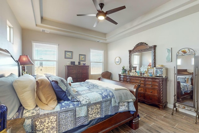 bedroom with ceiling fan and a raised ceiling