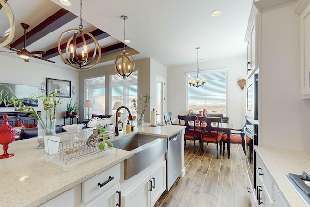 kitchen with white cabinetry, appliances with stainless steel finishes, a notable chandelier, and hanging light fixtures