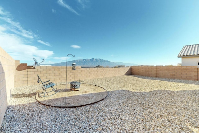 view of yard with an outdoor fire pit and a mountain view