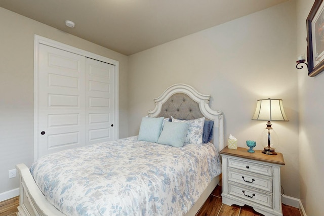 bedroom with dark wood-type flooring and a closet