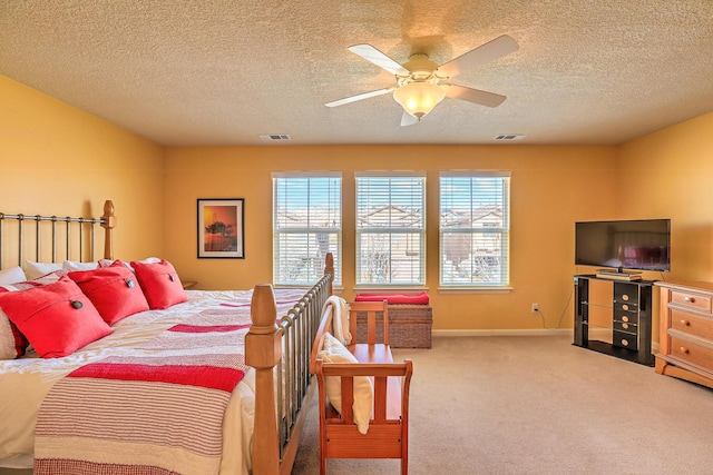 carpeted bedroom featuring visible vents, baseboards, a textured ceiling, and a ceiling fan