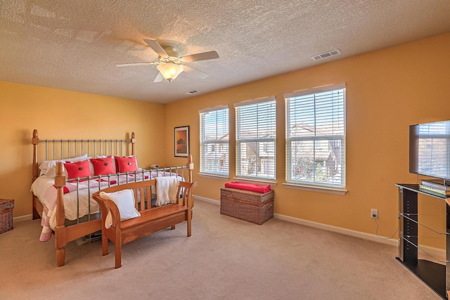 carpeted bedroom with visible vents, baseboards, a textured ceiling, and ceiling fan