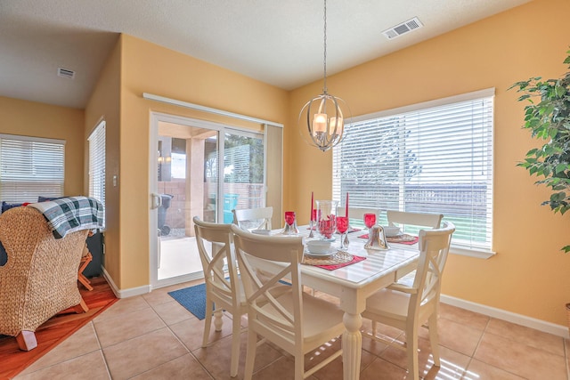 dining space with light tile patterned floors, visible vents, and a wealth of natural light