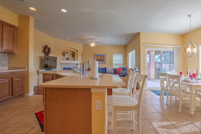 kitchen featuring light countertops, light tile patterned floors, open floor plan, and a sink