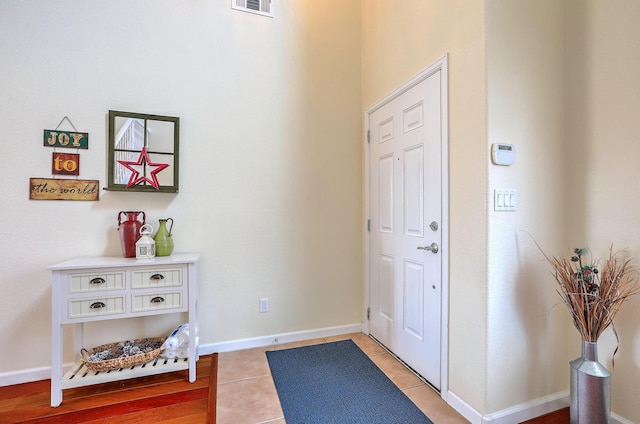 entryway with light tile patterned floors, visible vents, and baseboards