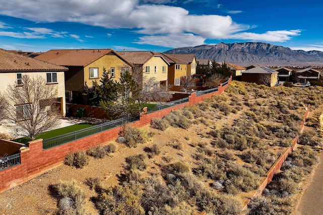 back of house featuring a residential view, stucco siding, a mountain view, and fence