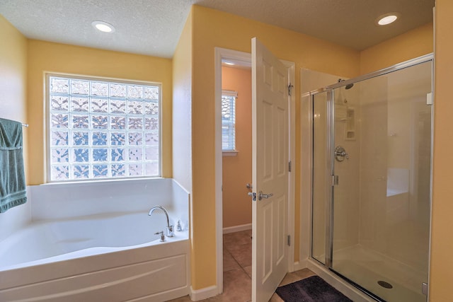 bathroom featuring recessed lighting, a stall shower, a textured ceiling, a garden tub, and tile patterned floors