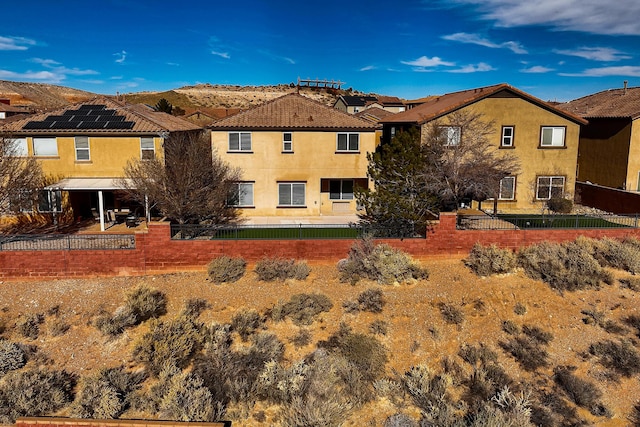 back of property featuring a patio, fence private yard, a mountain view, and stucco siding