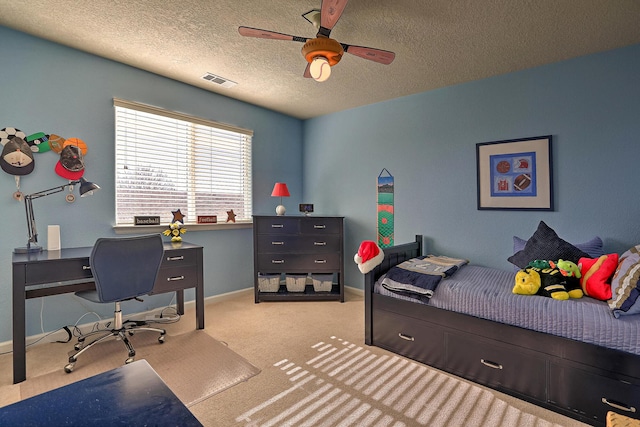 carpeted bedroom with visible vents, baseboards, a textured ceiling, and a ceiling fan