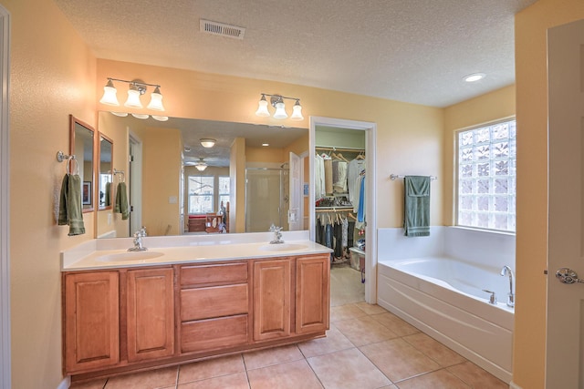 full bathroom with a spacious closet, visible vents, a stall shower, and a sink