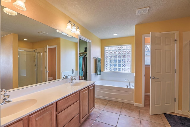 full bath featuring tile patterned flooring, visible vents, a stall shower, and a sink