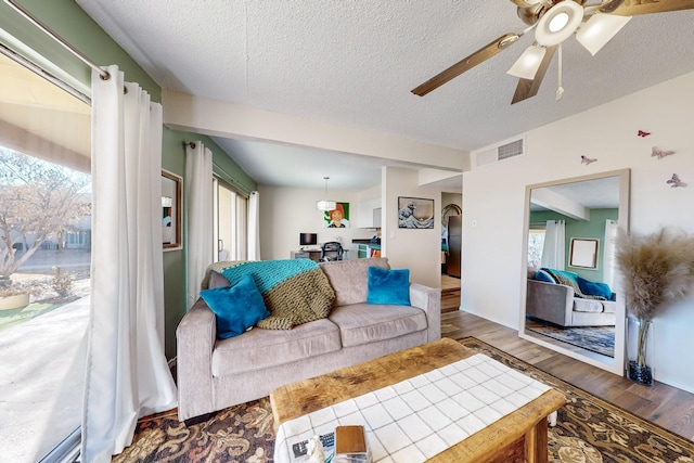 living room with a textured ceiling and dark wood-type flooring