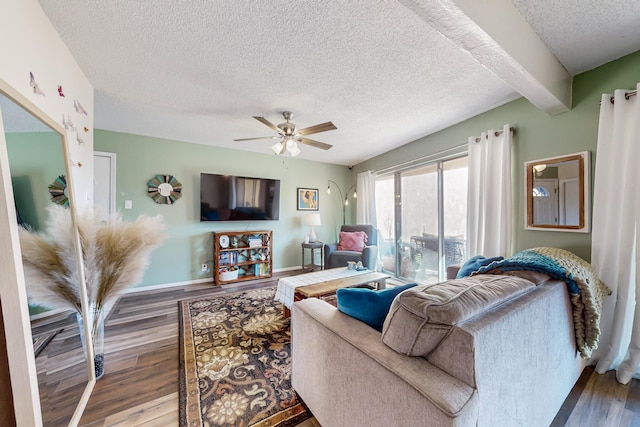 living room with a textured ceiling, dark hardwood / wood-style floors, and beamed ceiling