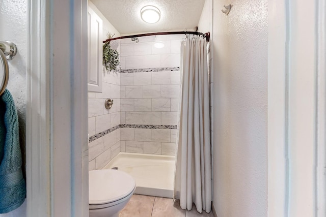 bathroom with a textured ceiling, toilet, a shower with curtain, and tile patterned flooring