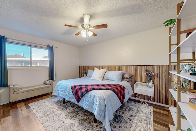 bedroom featuring ceiling fan, a textured ceiling, and hardwood / wood-style flooring