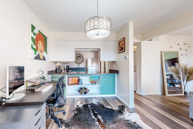 office area with sink, a textured ceiling, and hardwood / wood-style flooring