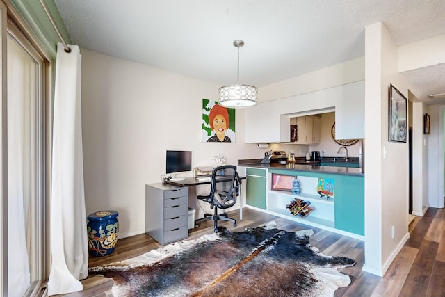 home office featuring sink, hardwood / wood-style floors, a textured ceiling, and a notable chandelier