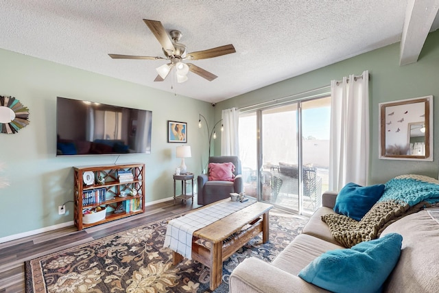 living room featuring a textured ceiling, dark wood-type flooring, and ceiling fan