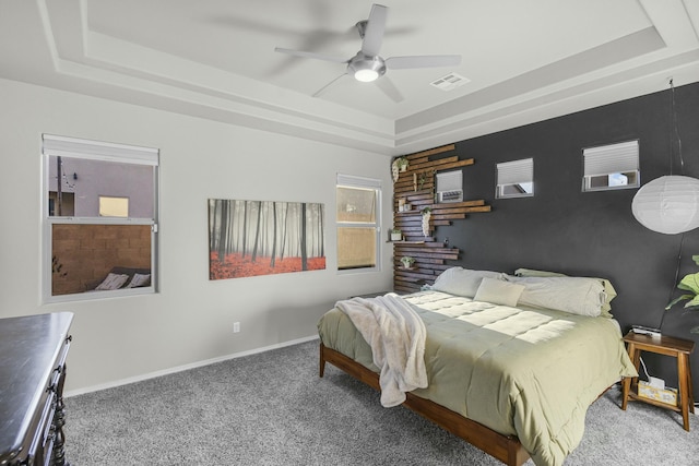 carpeted bedroom featuring ceiling fan and a raised ceiling