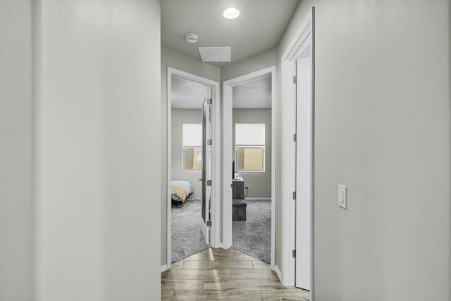 hall featuring light wood-type flooring and baseboards