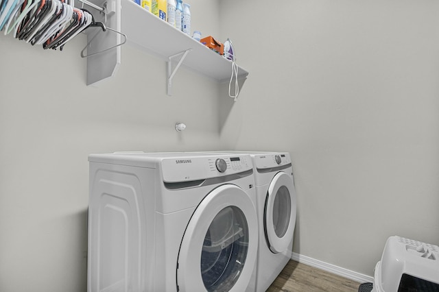 laundry room with separate washer and dryer and hardwood / wood-style floors