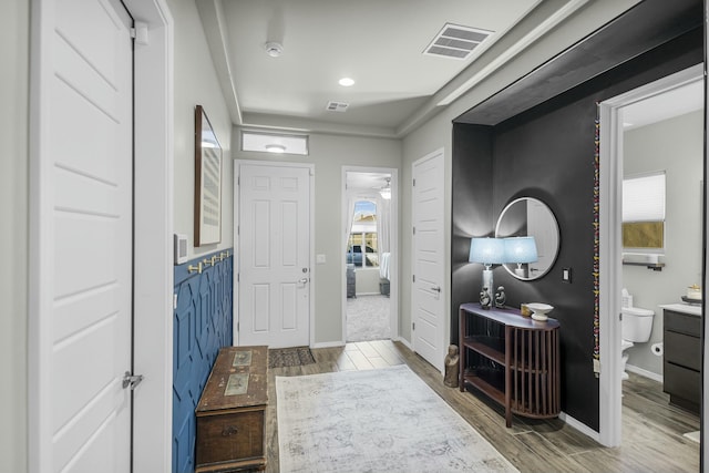 entryway with visible vents, baseboards, and wood finished floors