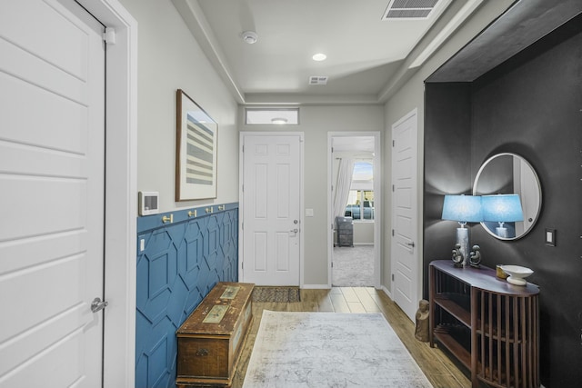 entryway featuring recessed lighting, visible vents, a wainscoted wall, and wood finished floors