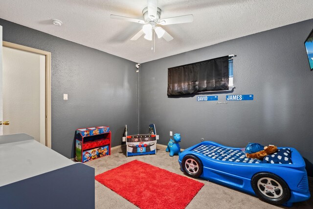 carpeted bedroom featuring ceiling fan, a textured ceiling, and a baseboard radiator