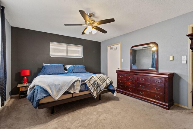 carpeted bedroom with ceiling fan, baseboard heating, and a textured ceiling