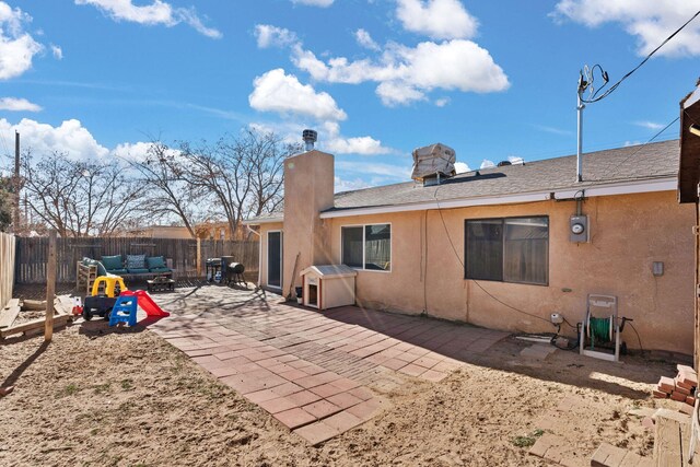 back of property with a storage unit and a patio