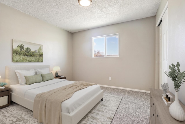 carpeted bedroom with a textured ceiling and a closet