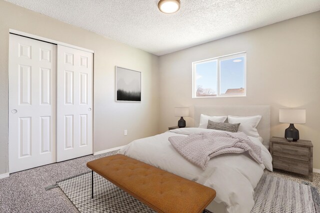 carpeted bedroom featuring a textured ceiling and a closet