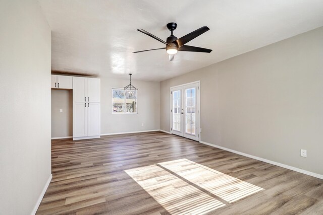 spare room featuring light hardwood / wood-style floors, ceiling fan, and french doors