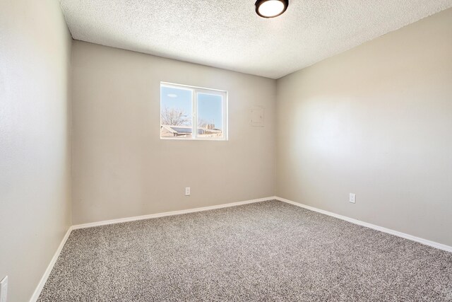 carpeted empty room featuring a textured ceiling