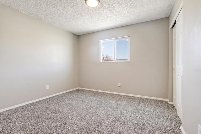 carpeted spare room with a textured ceiling