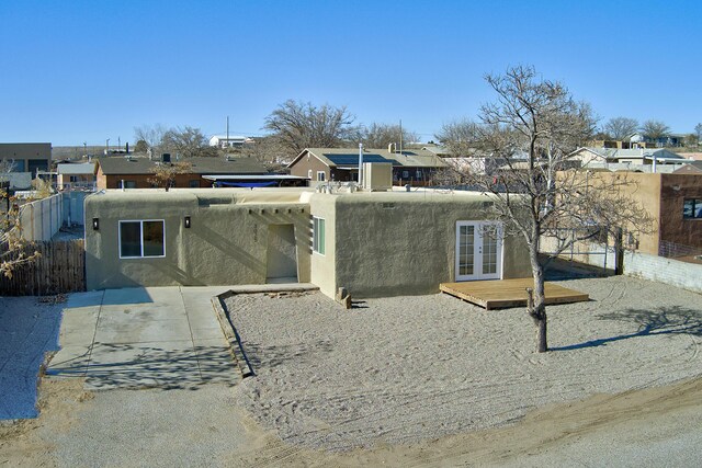 pueblo-style house featuring french doors