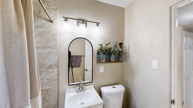 bathroom with toilet, a shower, and vanity