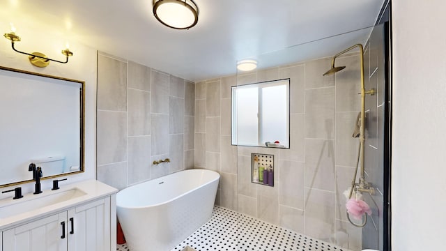 bathroom with plus walk in shower, tile walls, and vanity