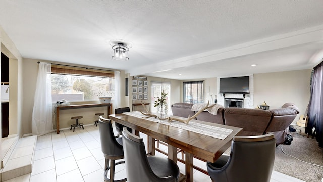 dining space with a textured ceiling and a fireplace