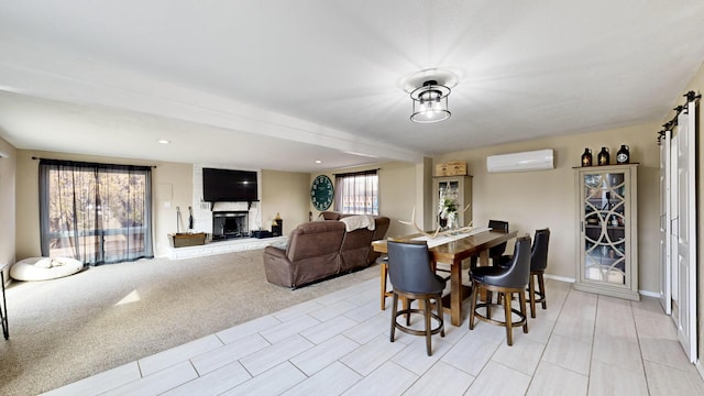 dining area featuring a fireplace, a wall mounted AC, and light colored carpet