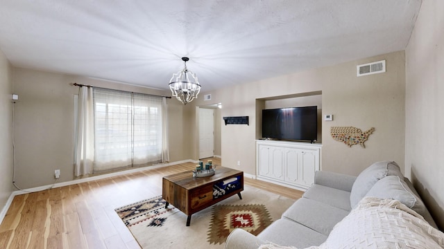 living room featuring a chandelier and light hardwood / wood-style floors