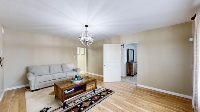 living room with light hardwood / wood-style floors and an inviting chandelier